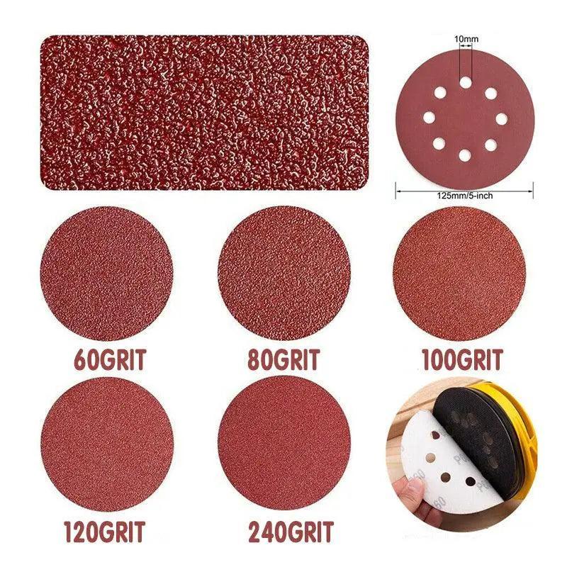 5-inch orbital sanding discs with 8 holes in assorted grits arranged on a flat surface — view 5
