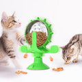 Interactive spinning windmill cat toy with suction cup base and treat dispensing chambers in plastic