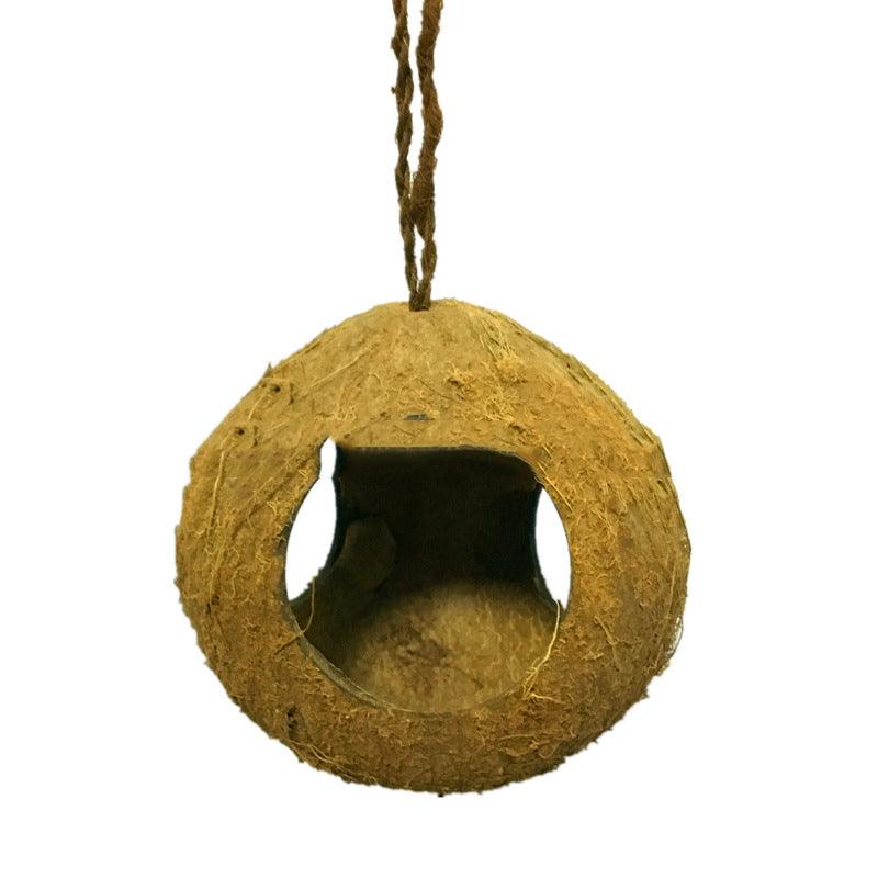 Rustic natural coconut shell bird nest feeder hanging from a garden branch outdoors — view 4