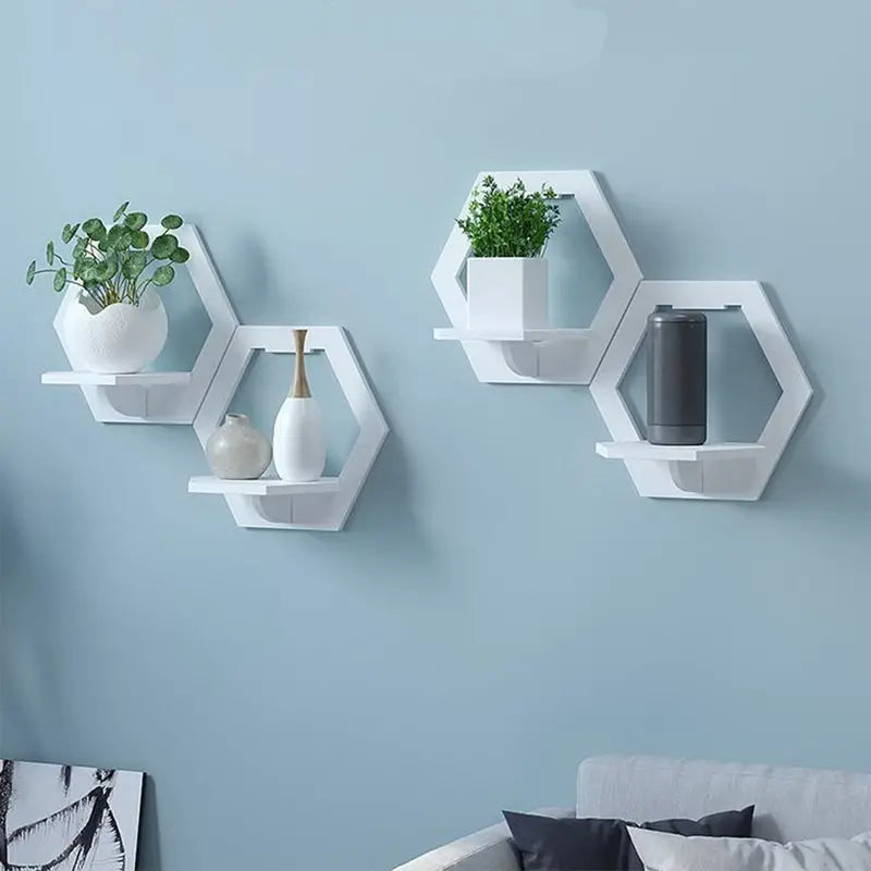 Set of 3 glossy white hexagonal floating wall shelves displaying small plants and picture frames — view 5