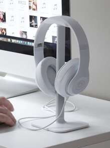 Modern white headphone stand with aluminum support bar resting securely on a flat desktop surface — view 2