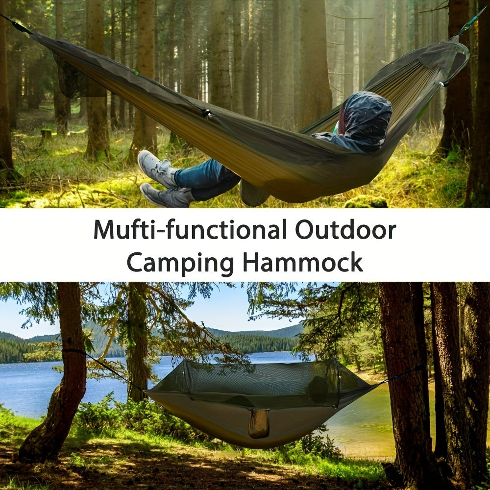 Green nylon double camping hammock with mosquito net hanging between two trees in a forest — view 5