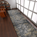 Abstract ivory and blue machine woven runner rug rolled out in a modern hallway setting