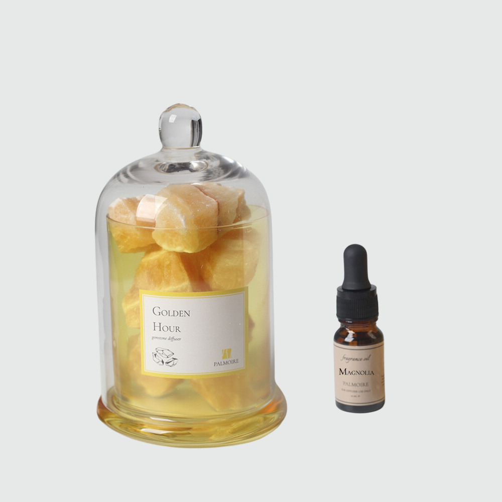 Golden hour gemstone diffuser with elegant decorative stones and luxury magnolia fragrance oil bottle