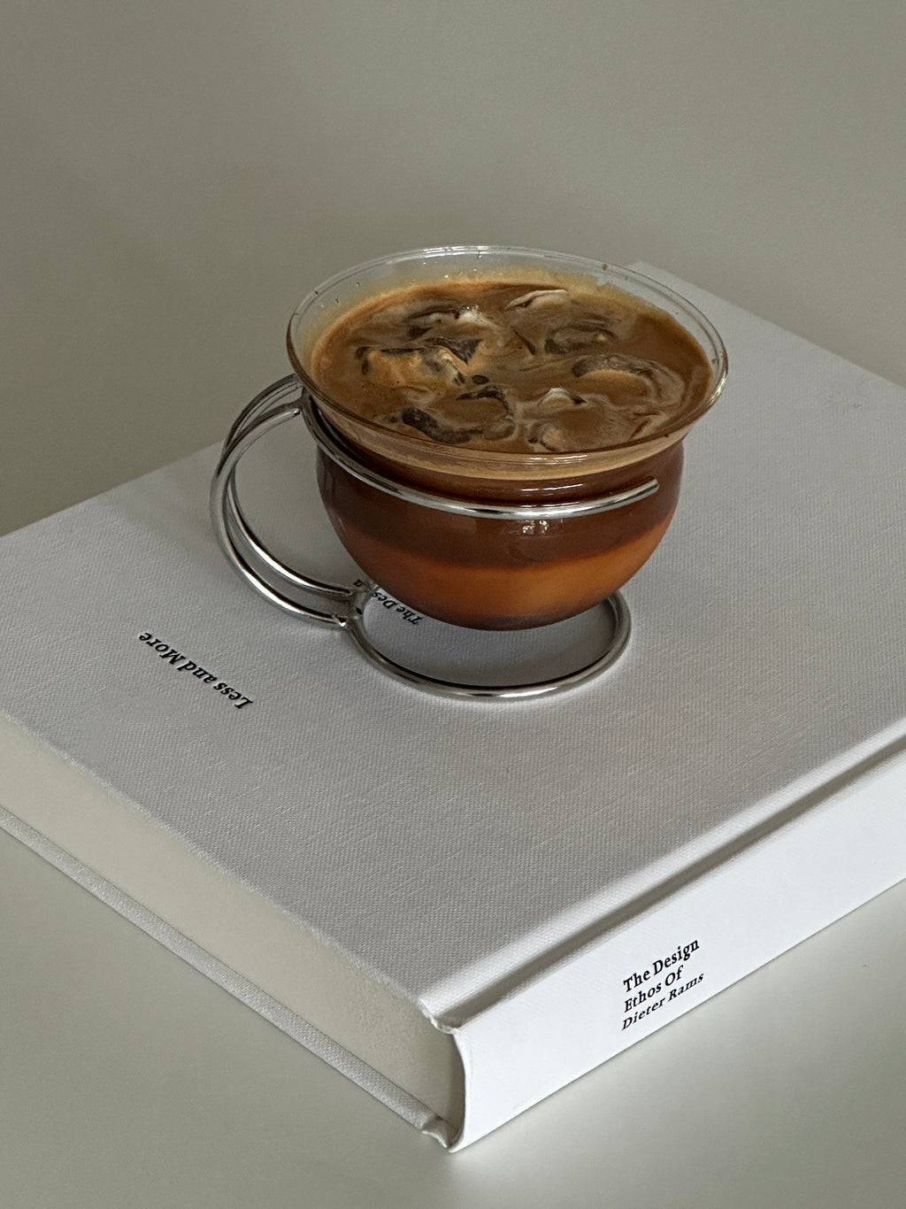Clear vintage glass coffee cup resting in a sleek minimalist stainless steel wire holder — view 2