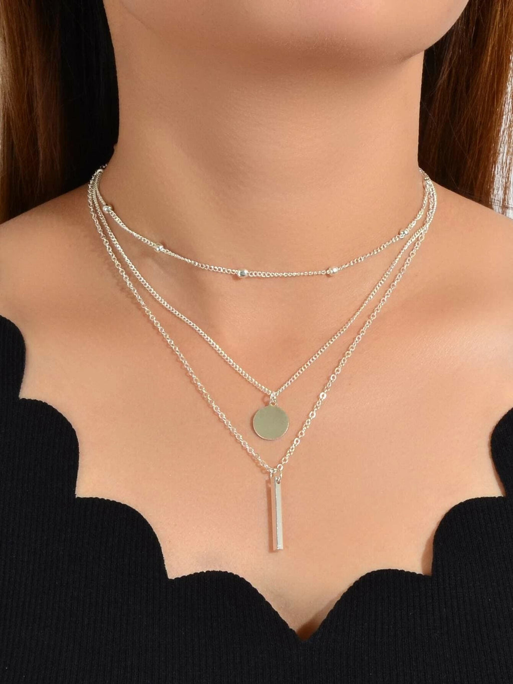 Boho multi-layer charm necklace with bar, disc, and round bead pendants on adjustable metallic chain. — view 5