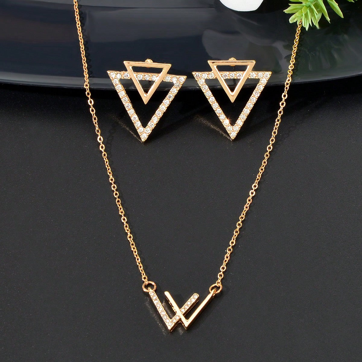Double V pendant necklace and matching triangle earrings set featuring polished metallic geometric design.