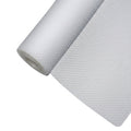 Transparent EVA cabinet shelf liner mat roll unrolled on a wooden kitchen drawer surface