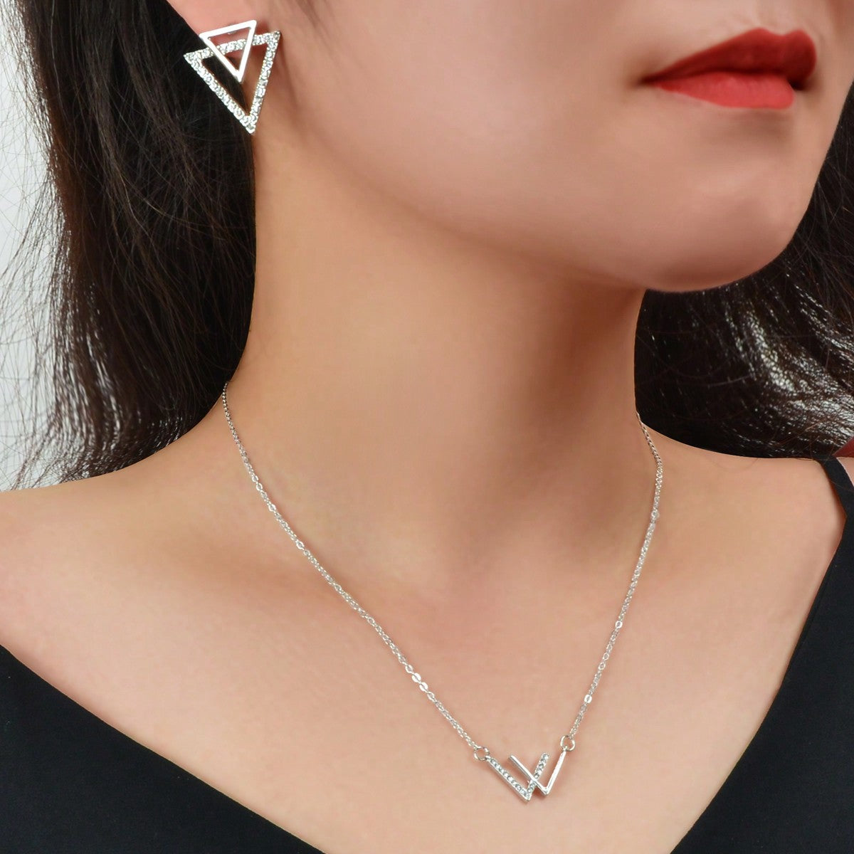 Double V pendant necklace and matching triangle earrings set featuring polished metallic geometric design. — view 5