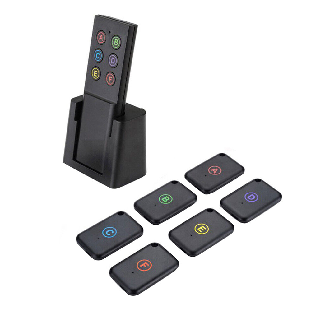 Wireless key finder set showing one black remote transmitter and six small tracker receivers — view 2