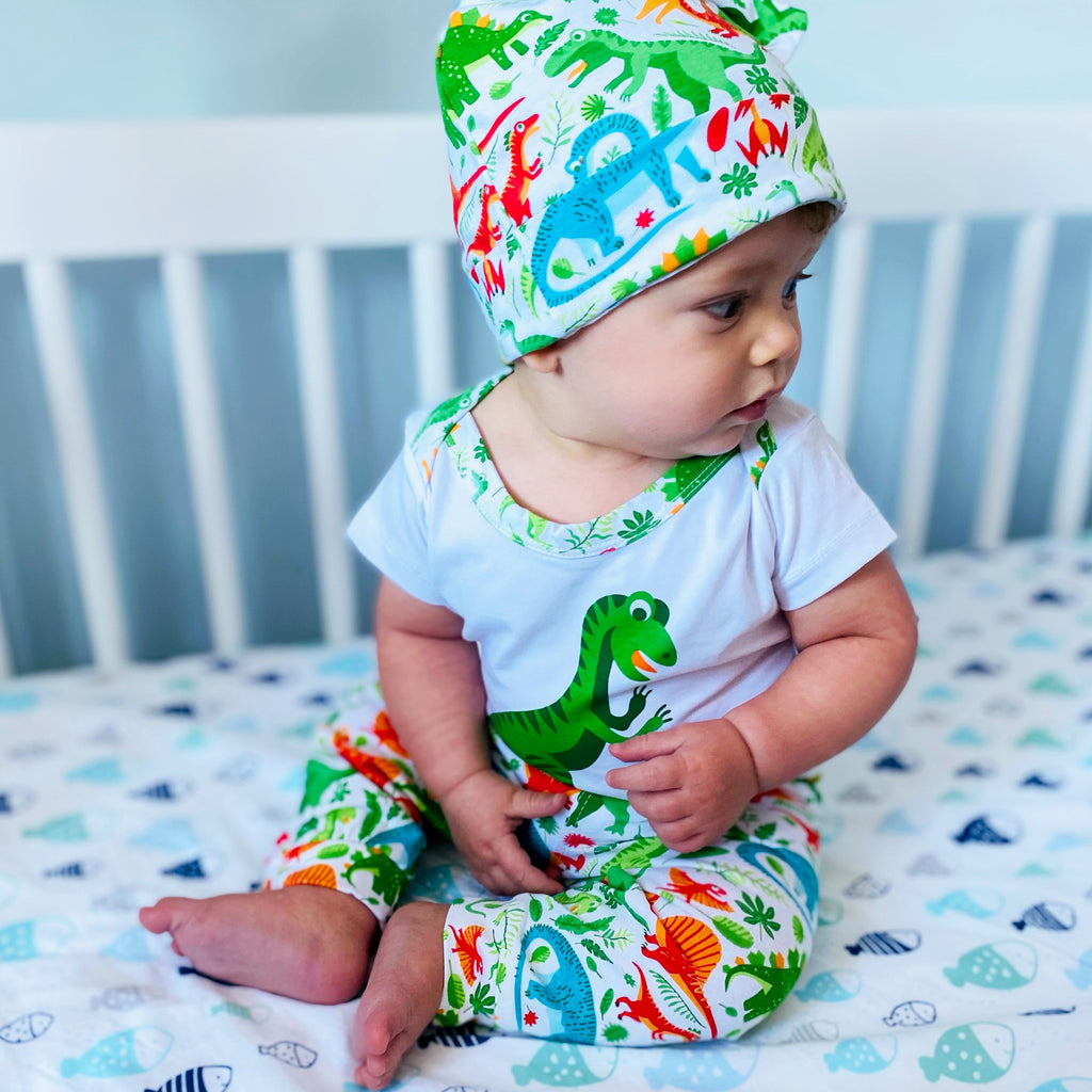 Baby boy 3-piece dinosaur layette set with bodysuit, green patterned joggers, and matching head cap — view 4