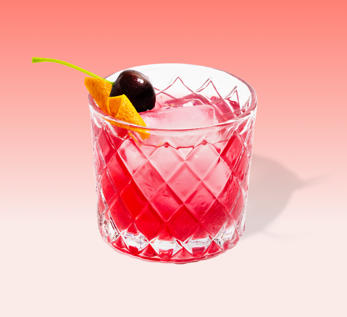 Black cherry old fashioned cocktail mix packet with a dark red drink over ice — view 2