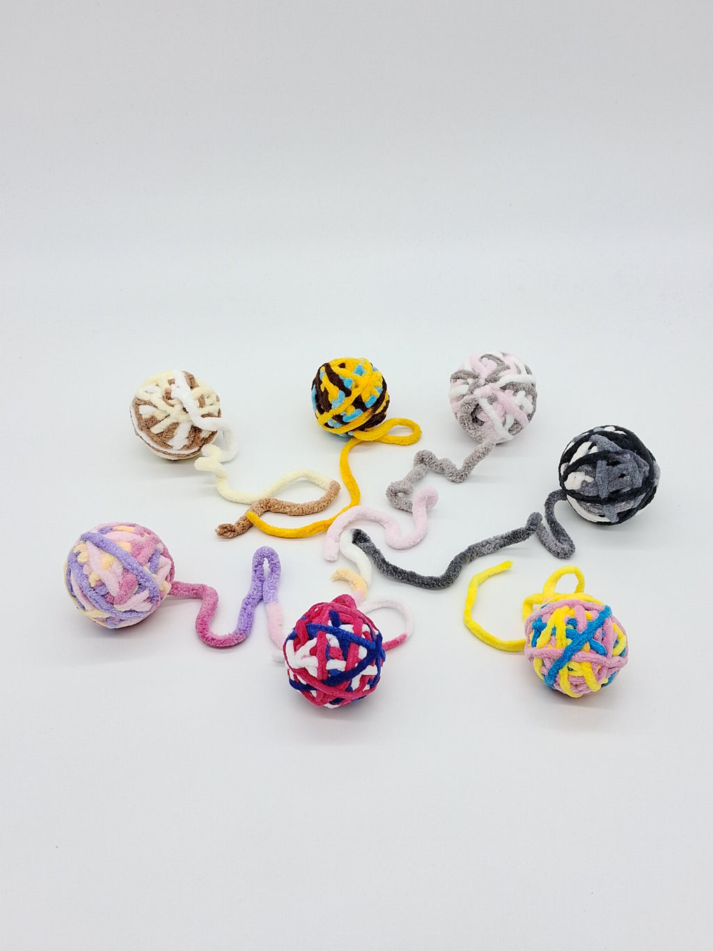 Large textured yarn ball cat toy in assorted colors with an interactive attached string tail