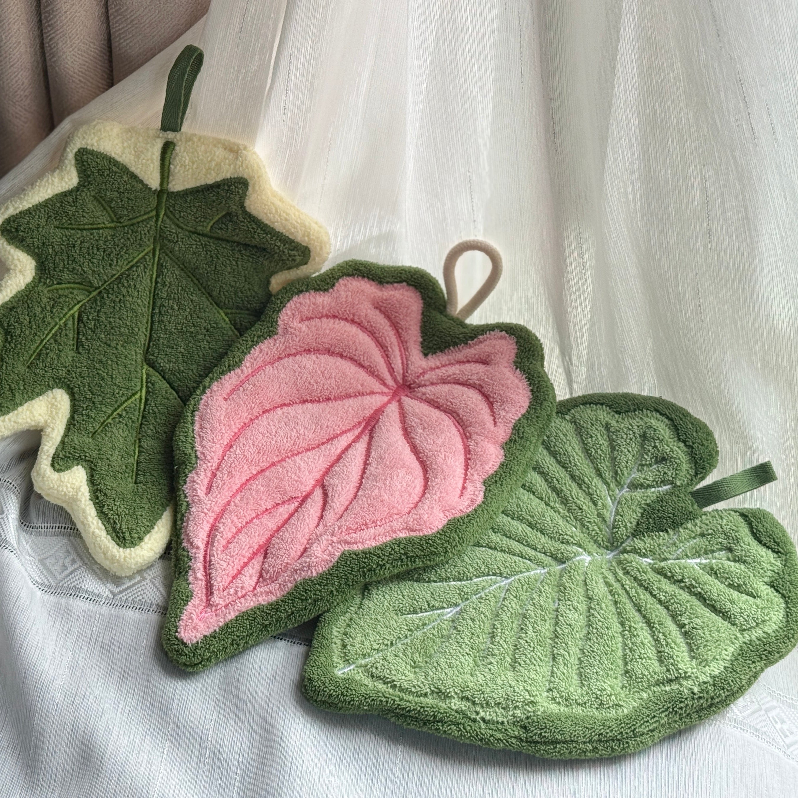 Set of three modern leaf shaped plush hanging hand towels in green, pink, and maple. — view 2