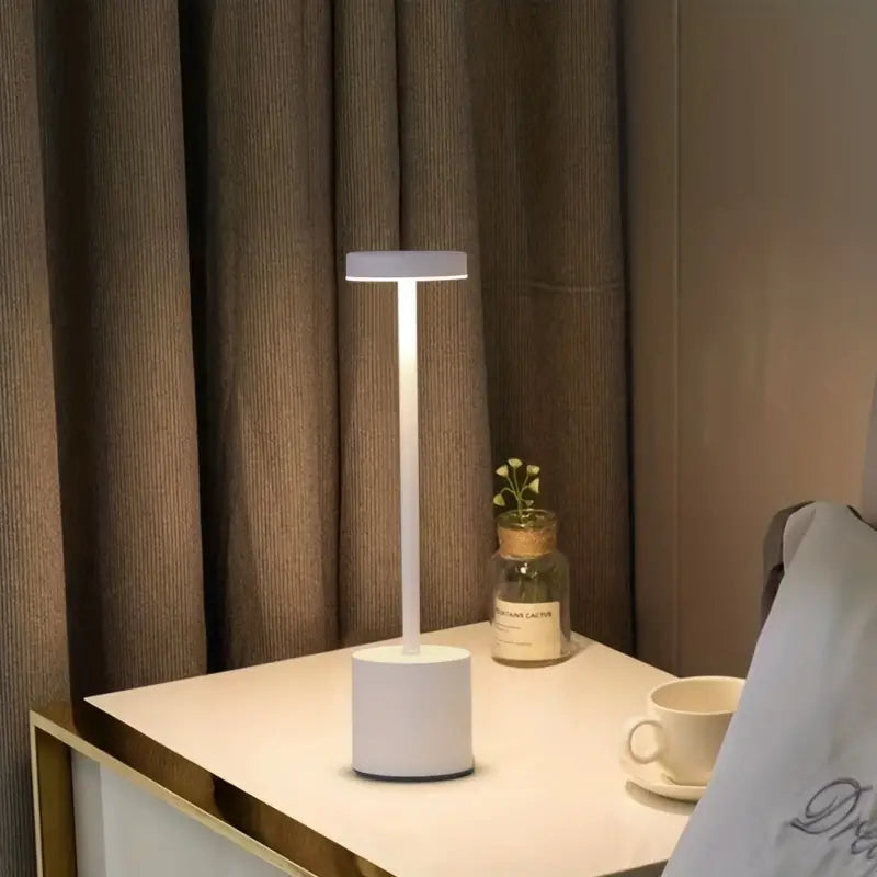 Minimalist wireless touch table lamp in polished aluminum on a bedside table — view 3