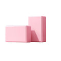 Two high-density foam yoga building blocks providing support and stability for fitness routines