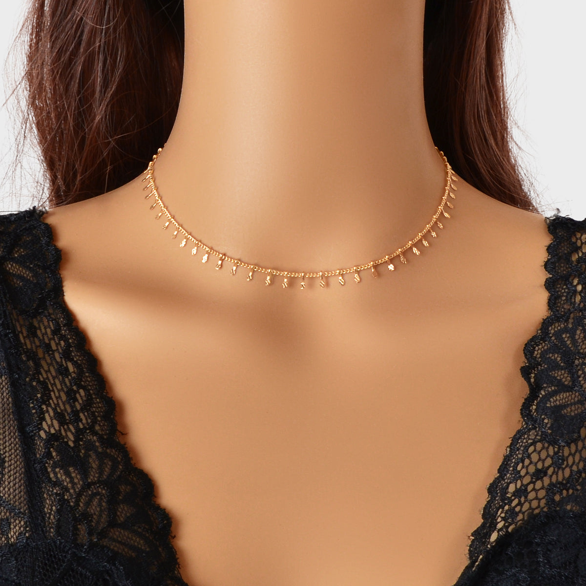 Dainty gold charm choker necklace on a delicate short chain for minimalist everyday fashion.