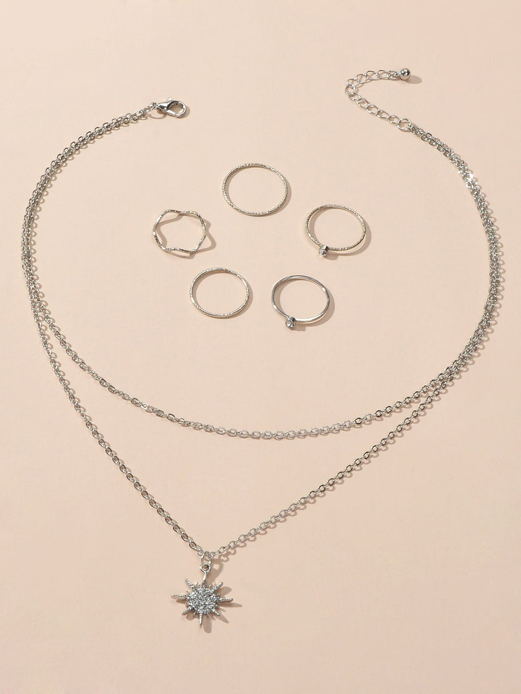 Silver double layer star pendant necklace and five matching knuckle rings displayed together as a set — view 2
