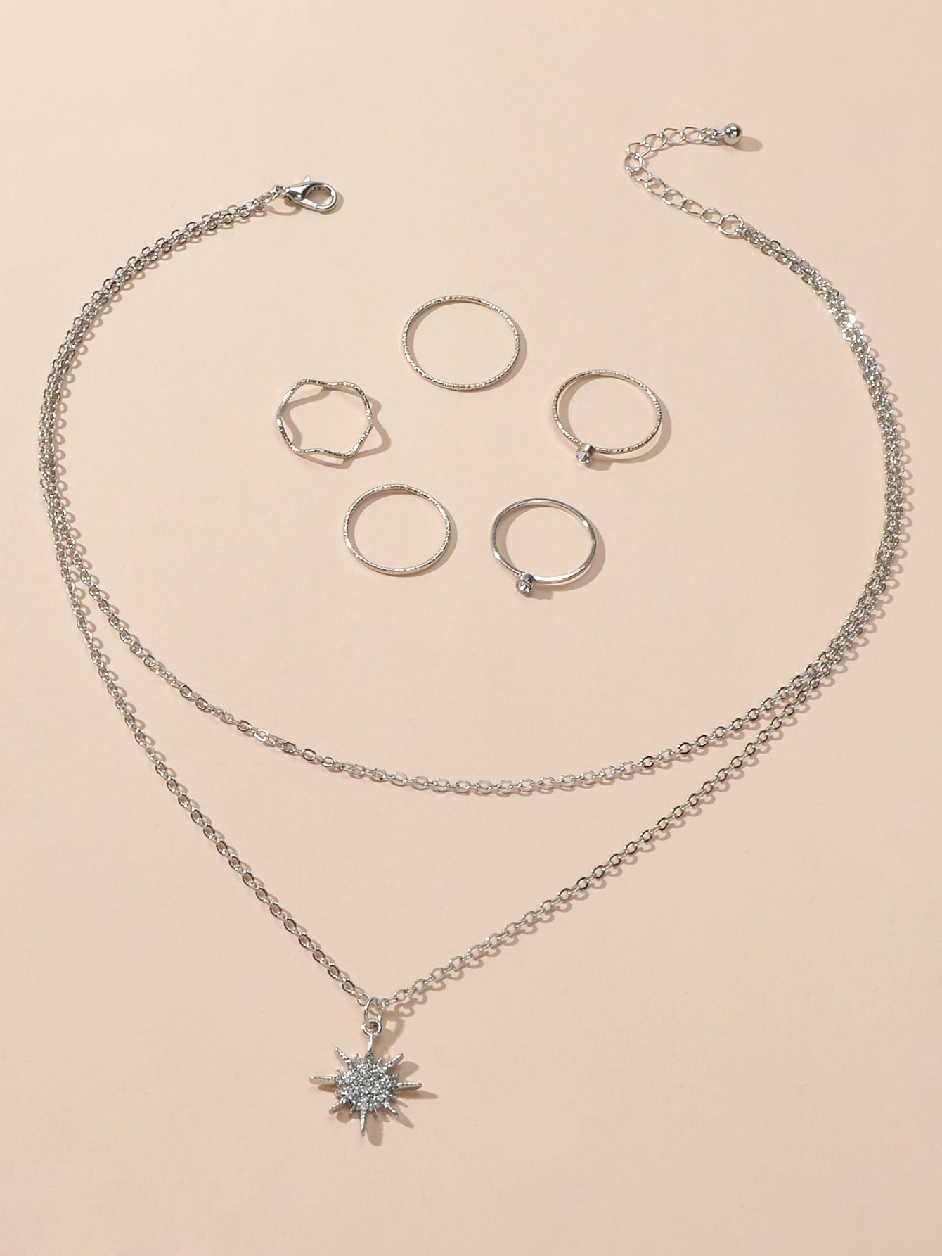 Silver double layer star pendant necklace and five matching knuckle rings displayed together as a set — view 2
