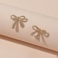 Sparkly rhinestone bow-knot stud earrings with a gold plated finish for elegant party wear.