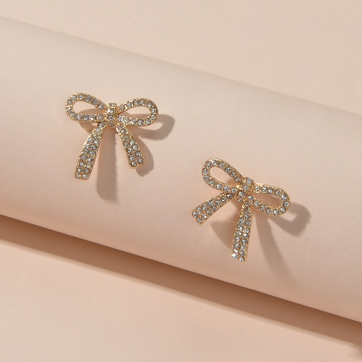 Sparkly rhinestone bow-knot stud earrings with a gold plated finish for elegant party wear.