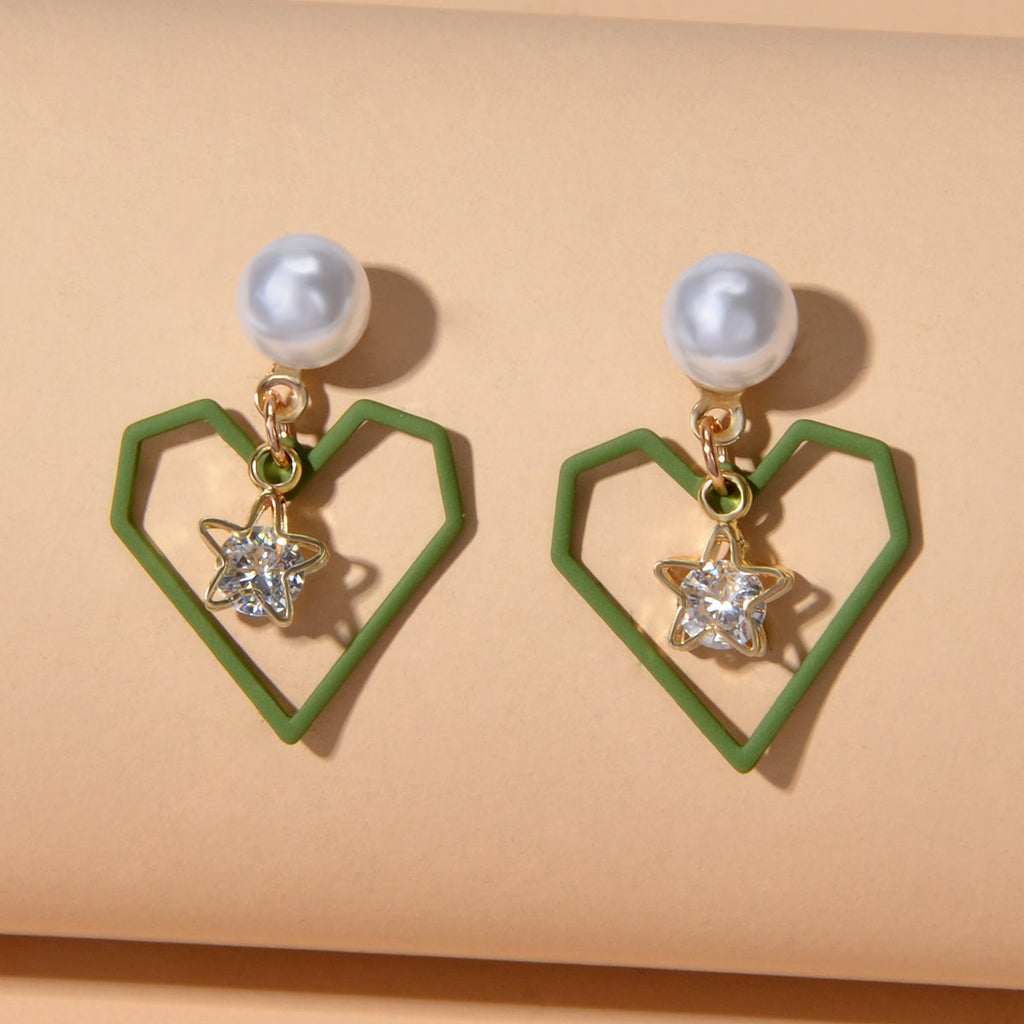Gold tone dangle earrings featuring rhinestone star and pearl heart decorations on a white background