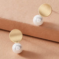 Dainty round gold metal faux pearl stud earrings for daily wear and elegant occasions.