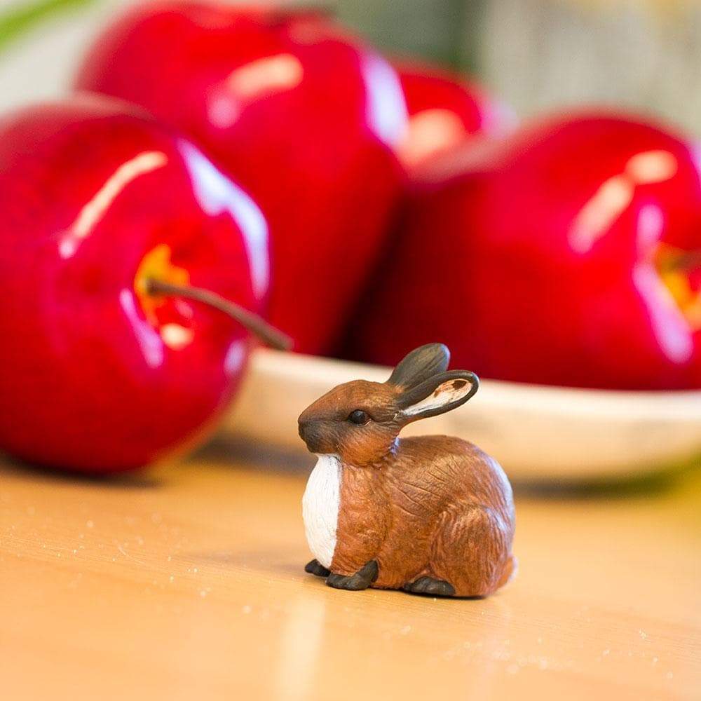 Small realistic brown rabbit toy figurine with textured fur and white chest on a plain background — view 5