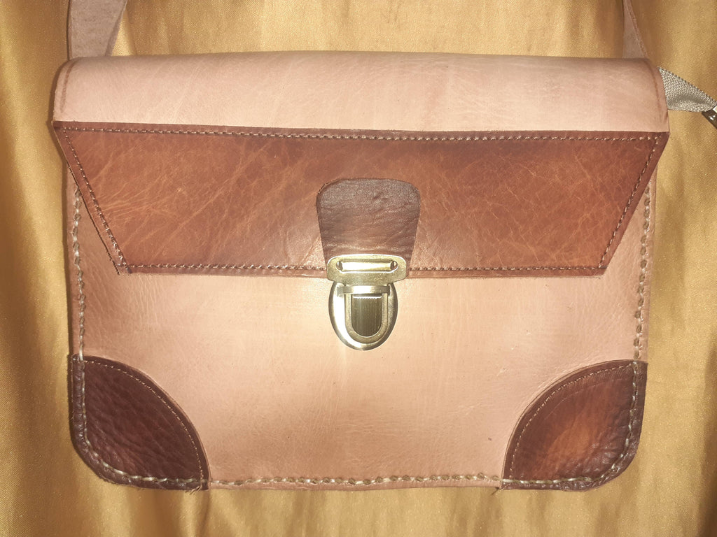 Two-tone leather crossbody bag with rustic finish, front zipper pocket, and long adjustable shoulder strap