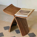 Sculptural wooden accent chair and multifunctional stool with a modern curved silhouette and natural grain finish