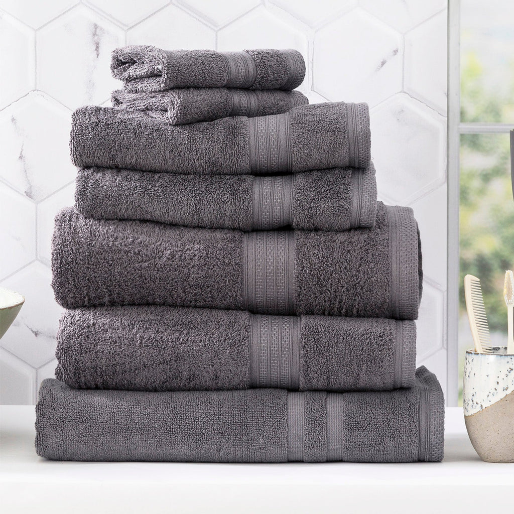 Charcoal grey bamboo cotton bath towel set neatly folded in a luxurious bathroom setting