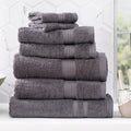 Charcoal grey bamboo cotton bath towel set neatly folded in a luxurious bathroom setting