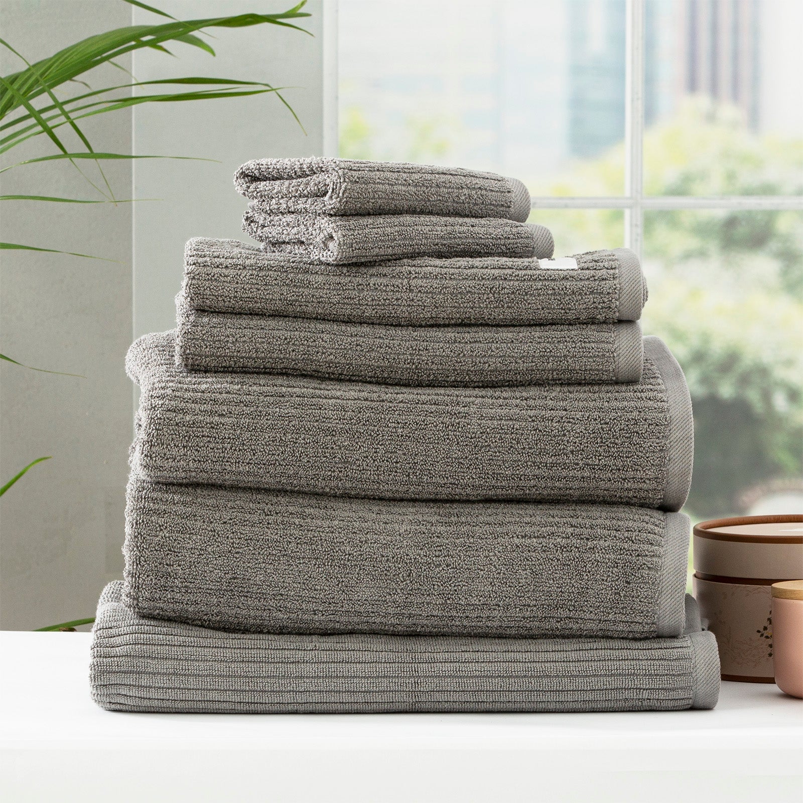 Folded stack of plush cobblestone ribbed platinum bath towels made from thick cotton yarn