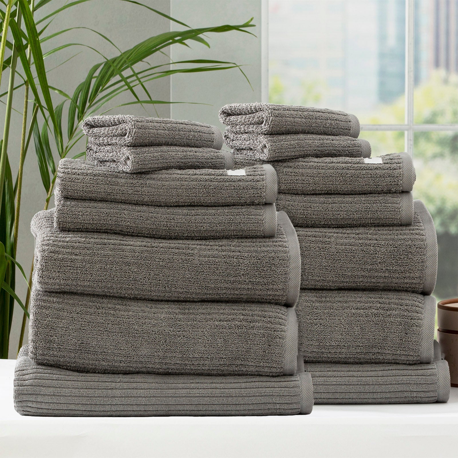 Folded stack of plush cobblestone ribbed platinum bath towels made from thick cotton yarn — view 2
