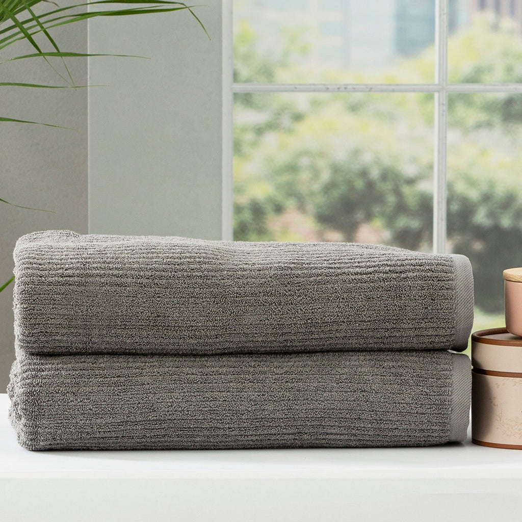 Folded stack of plush cobblestone ribbed platinum bath towels made from thick cotton yarn — view 3