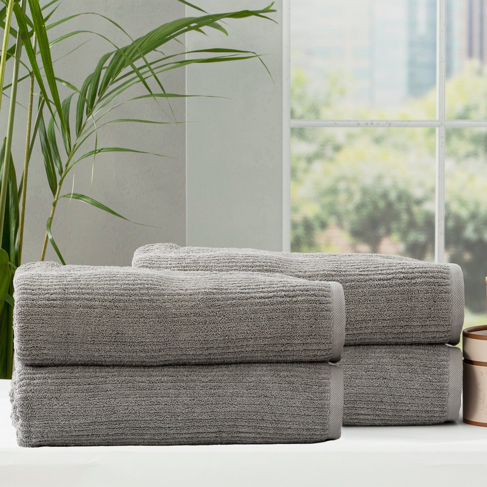 Folded stack of plush cobblestone ribbed platinum bath towels made from thick cotton yarn — view 4