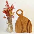 Handcrafted oak cutting board displaying natural wood grain on a clean kitchen countertop.