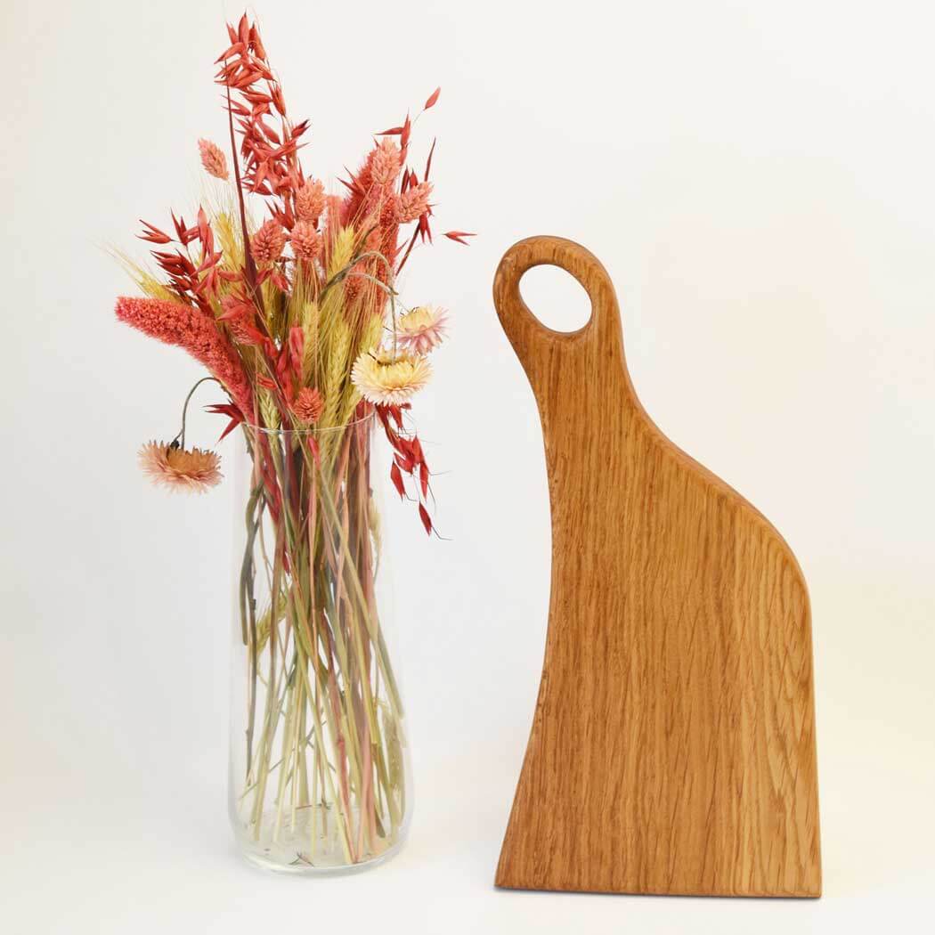Handcrafted oak cutting board displaying natural wood grain on a clean kitchen countertop. — view 2