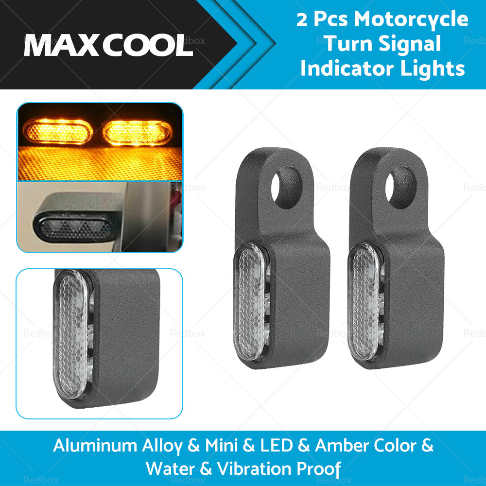 Two black aluminum mini LED motorcycle turn signals emitting bright amber blinker light. — view 2