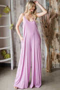 Women's V-neck wide leg jumpsuit with spaghetti straps, side pockets, and tied detailing