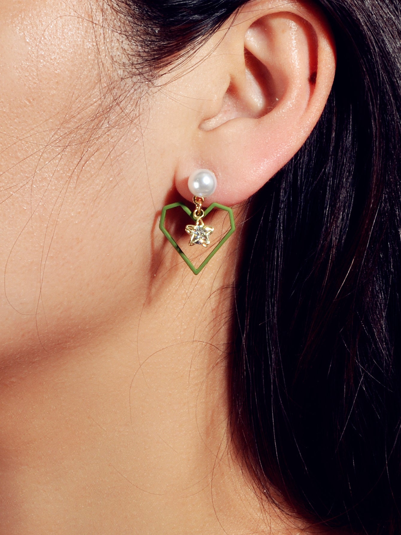 Gold tone dangle earrings featuring rhinestone star and pearl heart decorations on a white background — view 2