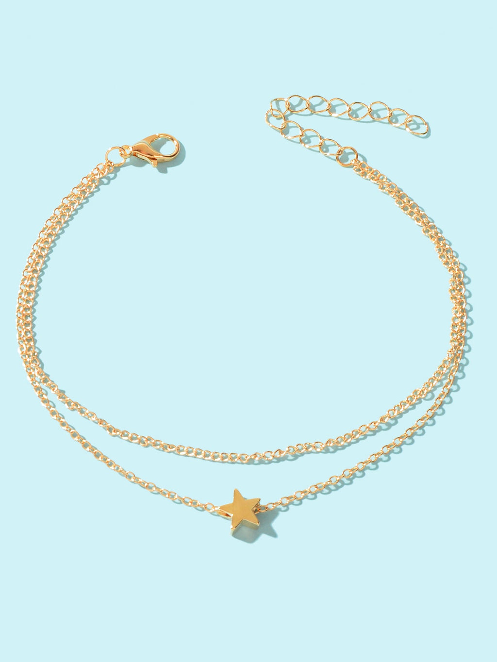 Minimalist double layered gold chain anklet featuring delicate star charms on a plain background — view 2