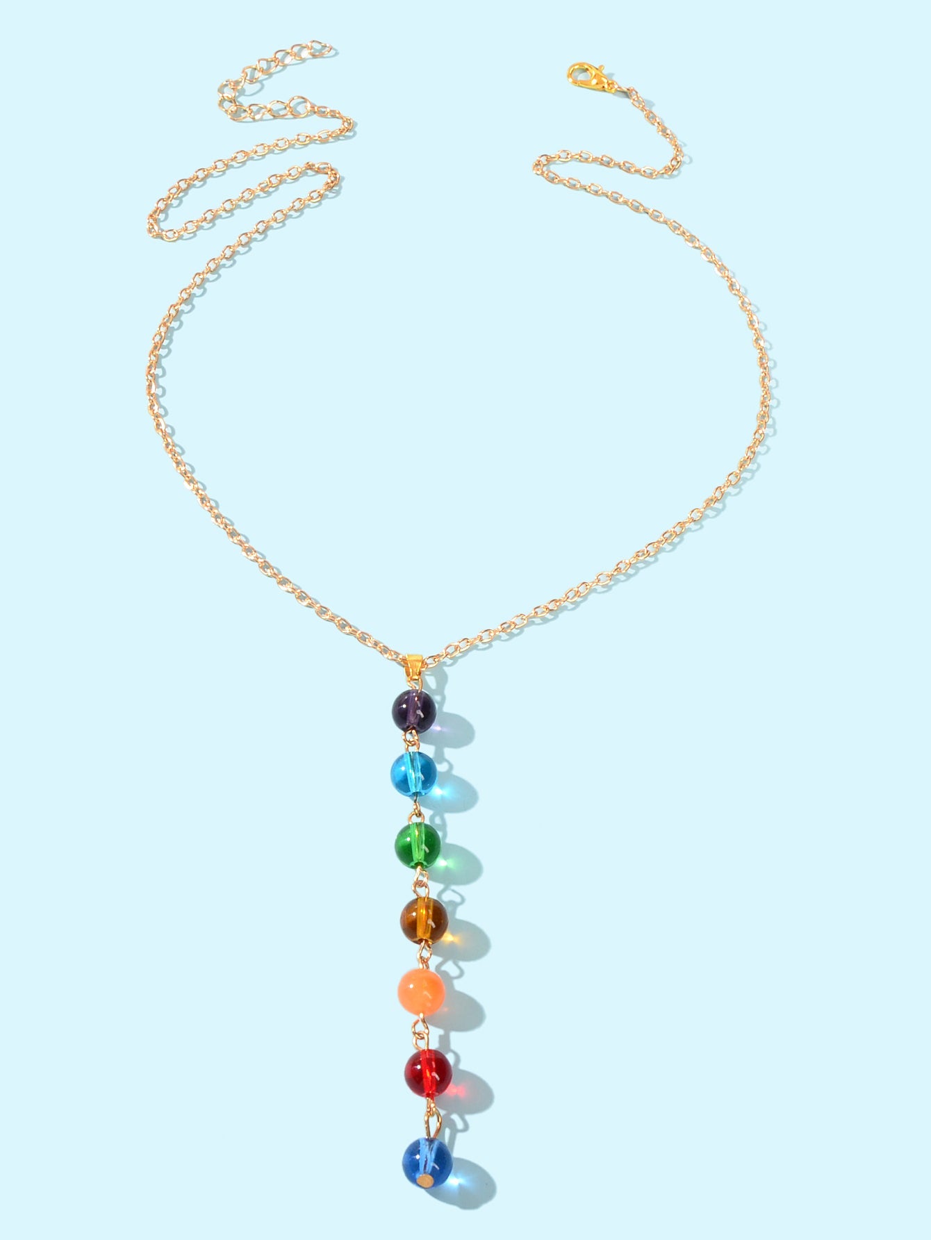 Dainty gold chain Y-shape lariat necklace with colorful glass beads on a female neckline — view 2