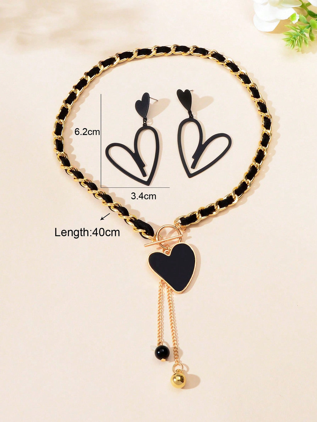 Black heart pendant necklace and matching earrings set crafted from polished metal with dark centerpieces. — view 3