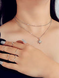 Silver double layer star pendant necklace and five matching knuckle rings displayed together as a set