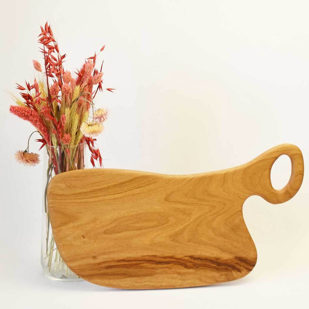 Handcrafted oak cutting board displaying natural wood grain on a clean kitchen countertop. — view 5