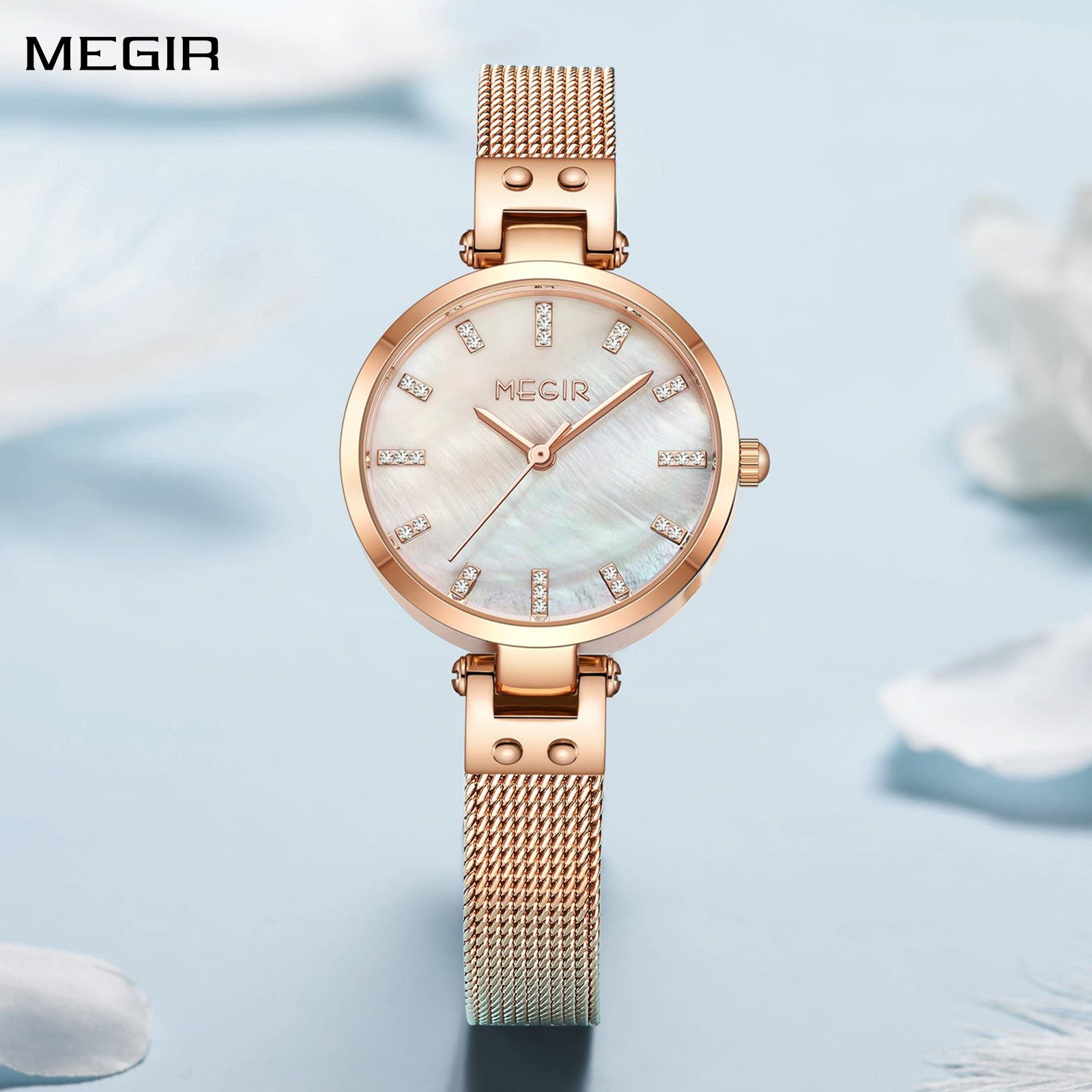 Women's quartz wristwatch featuring a round brass case and elegant metallic mesh steel band.
