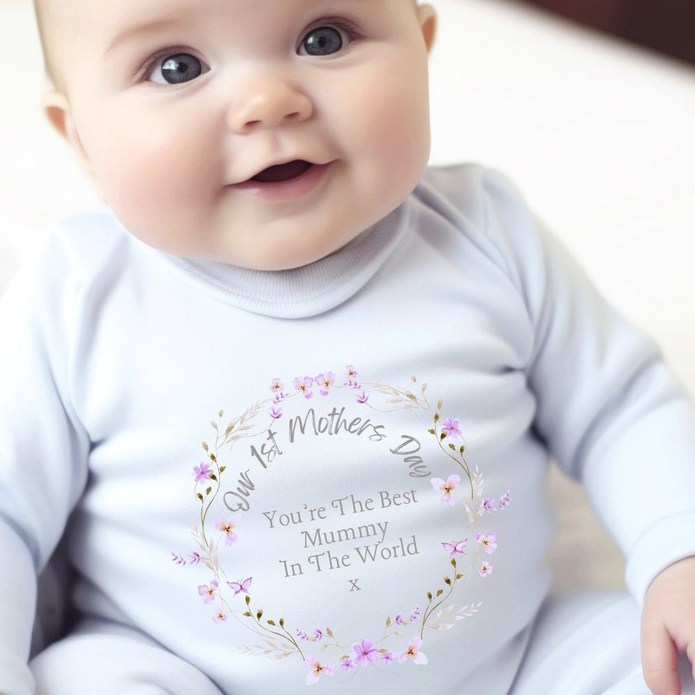 White baby grow, vest, and bib featuring a colorful floral first Mother's Day printed design