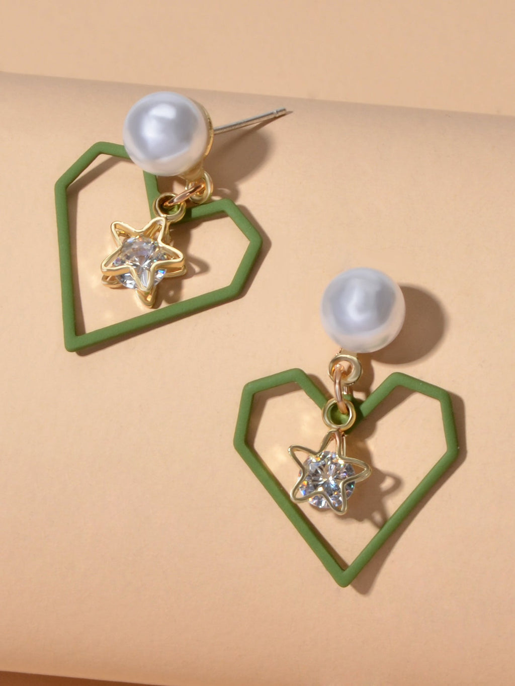 Gold tone dangle earrings featuring rhinestone star and pearl heart decorations on a white background — view 3