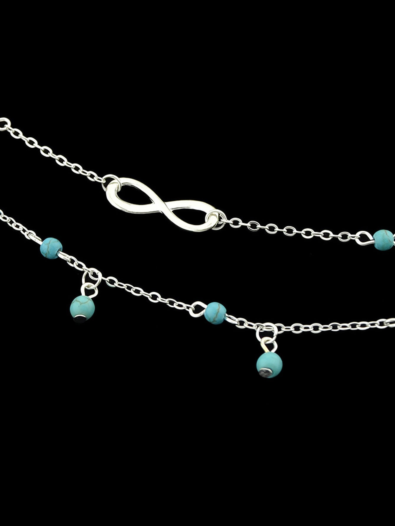 Turquoise infinity anklet with double layer silver chain worn on a bare foot. — view 3